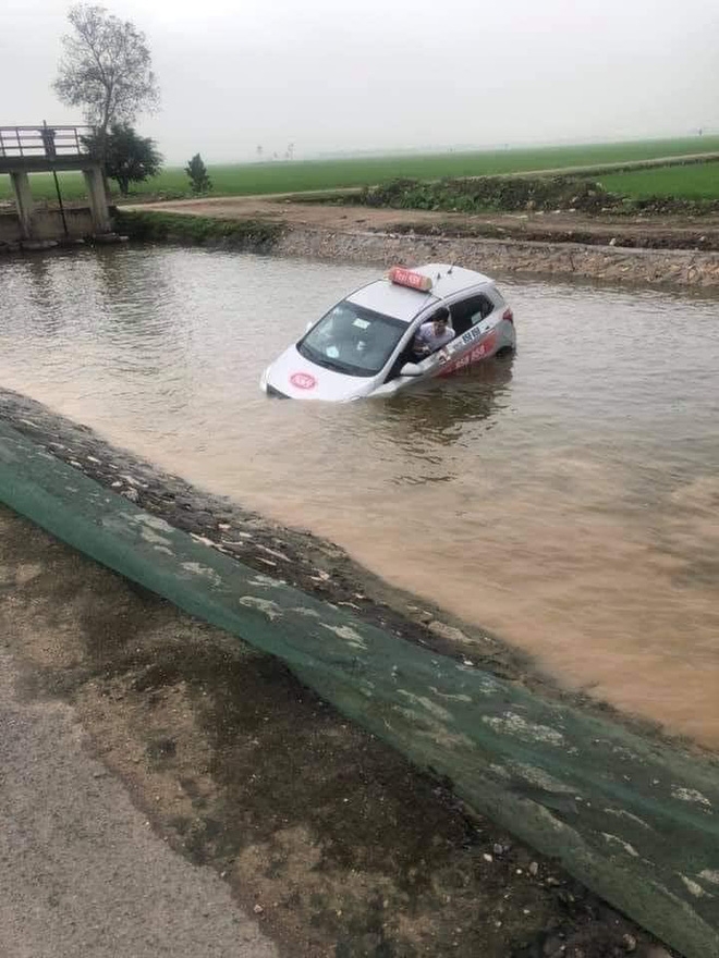 Chiếc xe chìm dưới mương nước sâu bên đường.